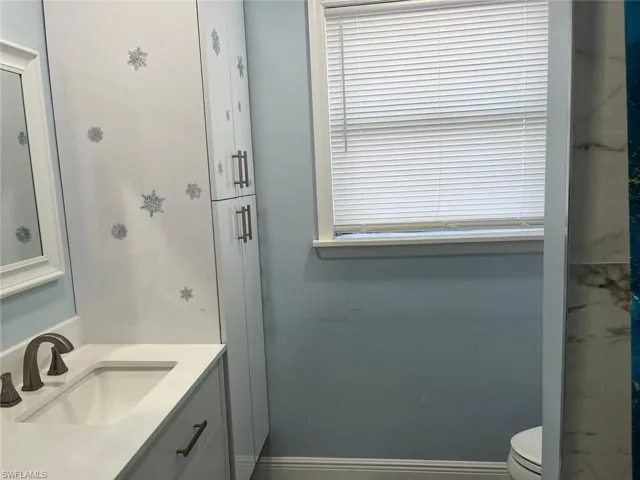 Bathroom featuring vanity, toilet, and an enclosed shower