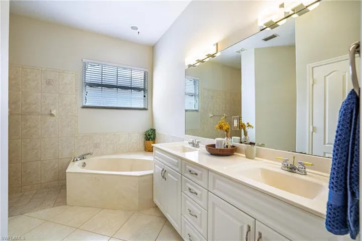 Bathroom featuring walk in shower, light tile patterned flooring, and a bath
