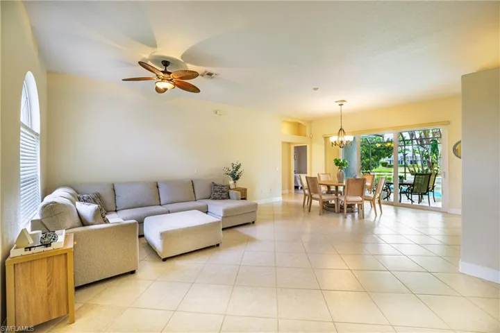 Living room with a ceiling fan and light tile patterned floors