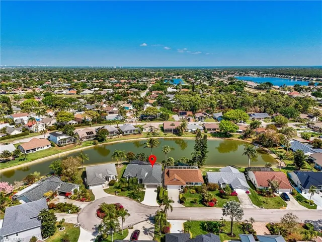 Aerial view of property and surrounding area featuring a large body of water and nearby suburban area