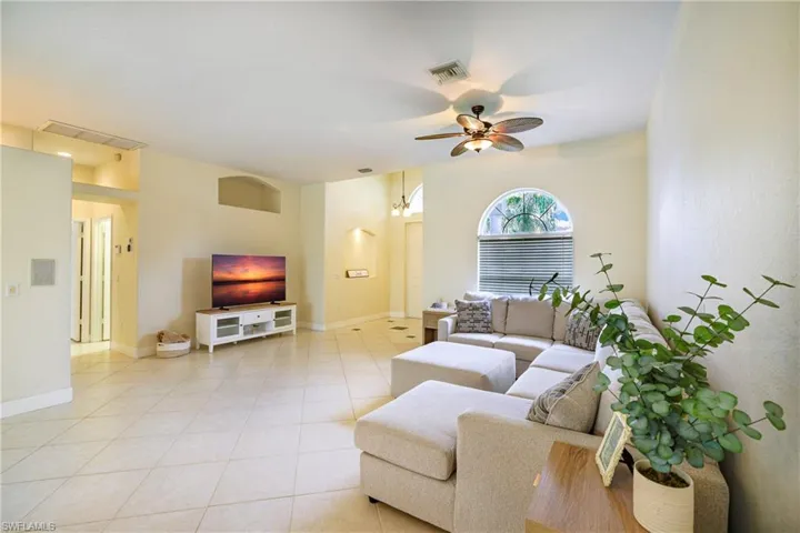 Living room with ceiling fan and light tile patterned floors