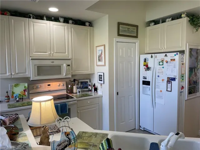 Kitchen featuring white appliances and white cabinets