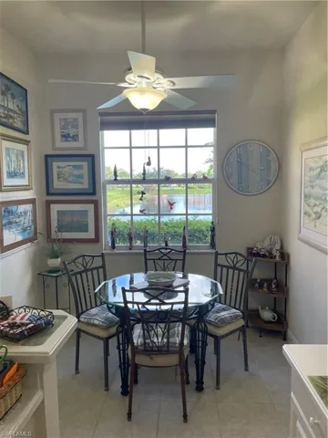 Dining area featuring ceiling fan, light tile patterned floors, and a water view