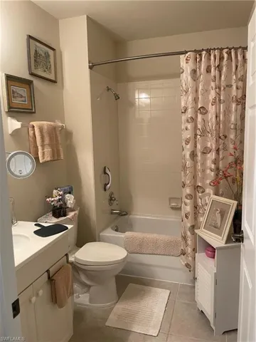 Full bathroom featuring tile patterned floors, shower / bath combo, toilet, and vanity