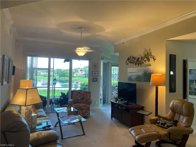 Living room featuring ornamental molding and ceiling fan