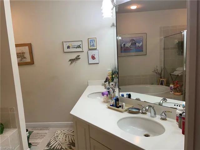 Bathroom featuring plus walk in shower and vanity