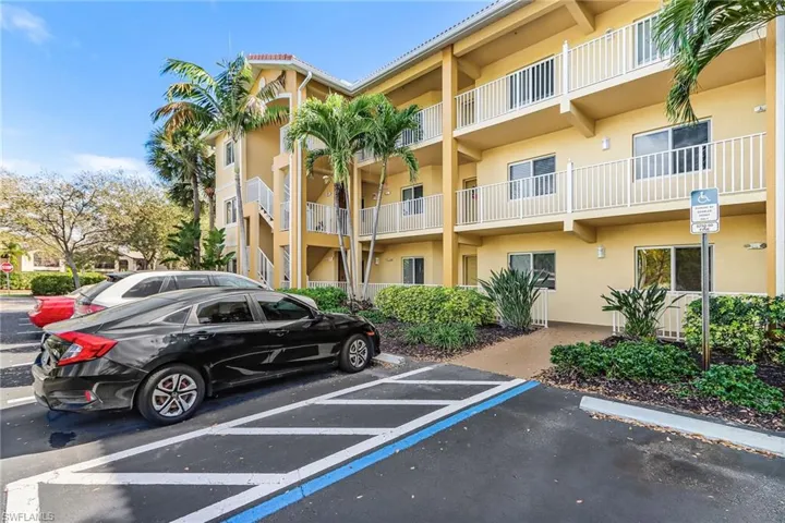 View of apartment building / complex with uncovered parking