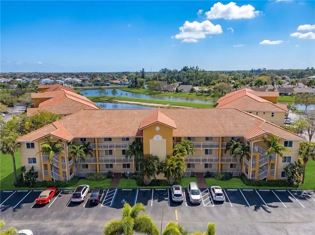 View of building exterior with a water view and uncovered parking