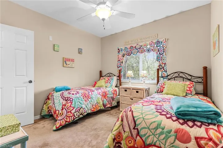 Bedroom with light colored carpet and a ceiling fan