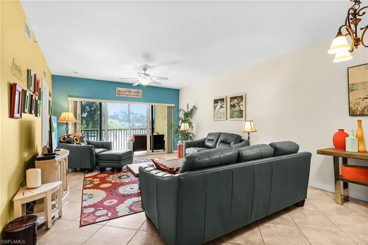 Living room with a ceiling fan and light tile patterned floors