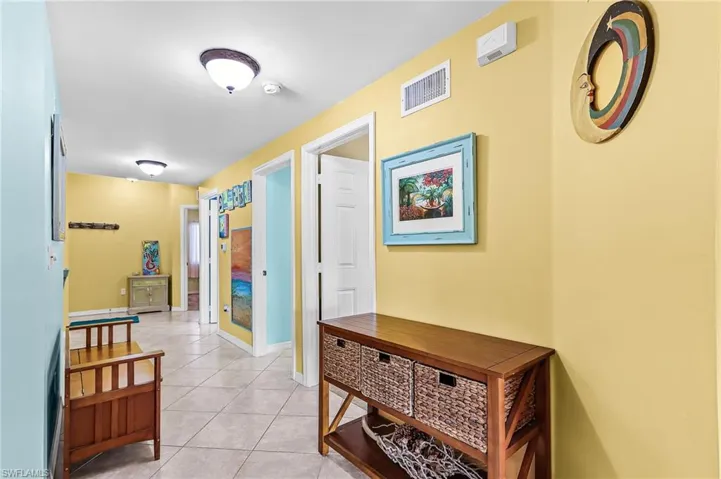 Corridor featuring light tile patterned flooring and baseboards