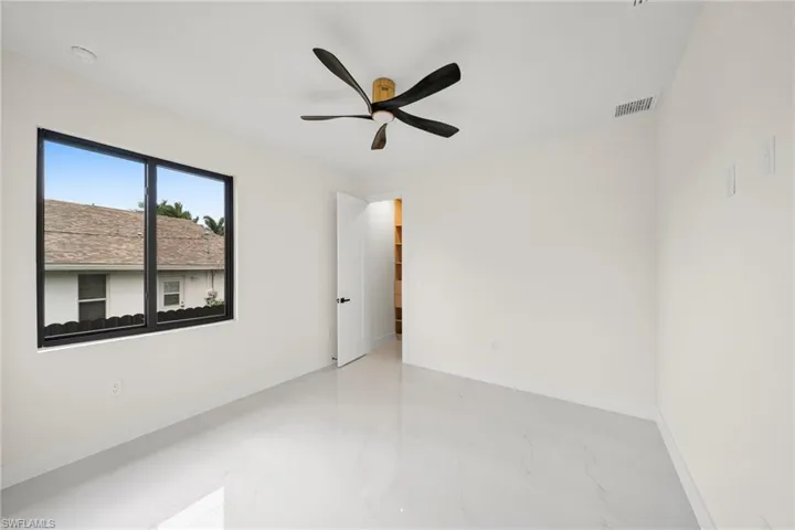 Empty room with marble finish floors and ceiling fan