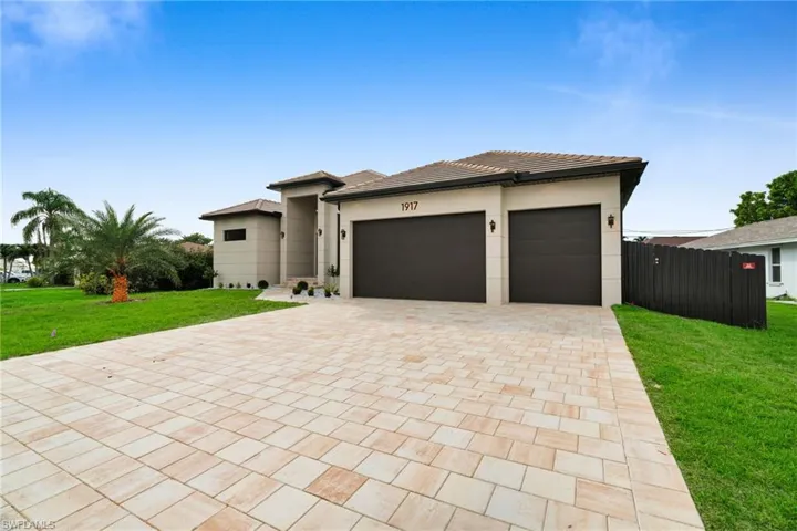 Prairie-style home with decorative driveway, an attached garage, a tile roof, and stucco siding