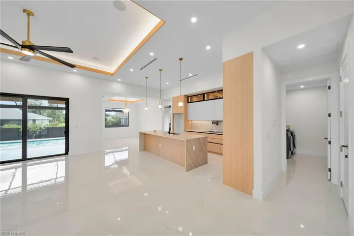 Kitchen featuring modern cabinets, a ceiling fan, a spacious island, recessed lighting, and pendant lighting