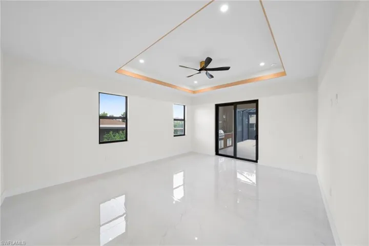 Unfurnished room with marble tiled flooring, recessed lighting, a raised ceiling, and a ceiling fan