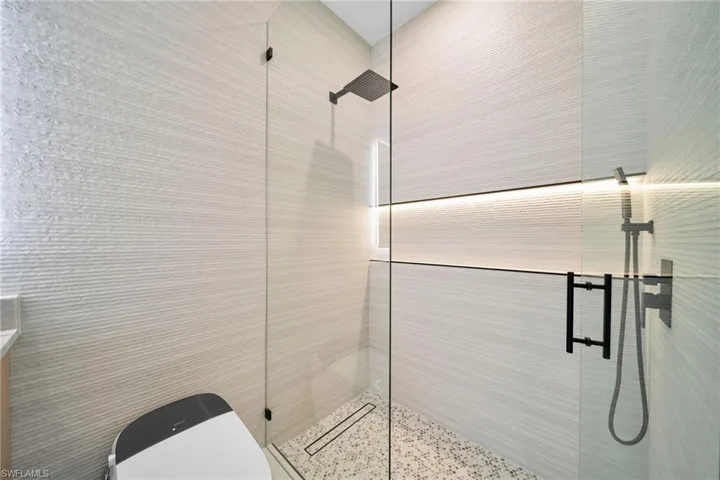 Full bathroom featuring a tile shower and toilet