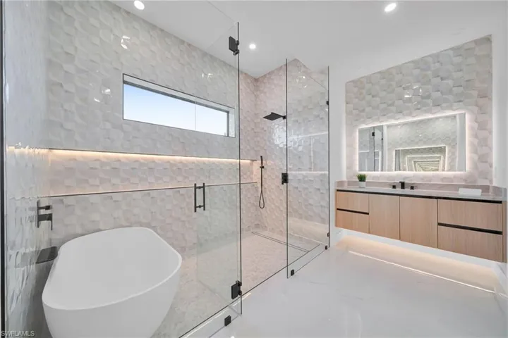 Full bathroom featuring a soaking tub, a stall shower, vanity, and recessed lighting