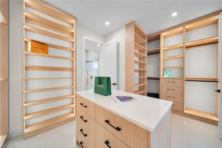 Spacious closet featuring light marble finish floors