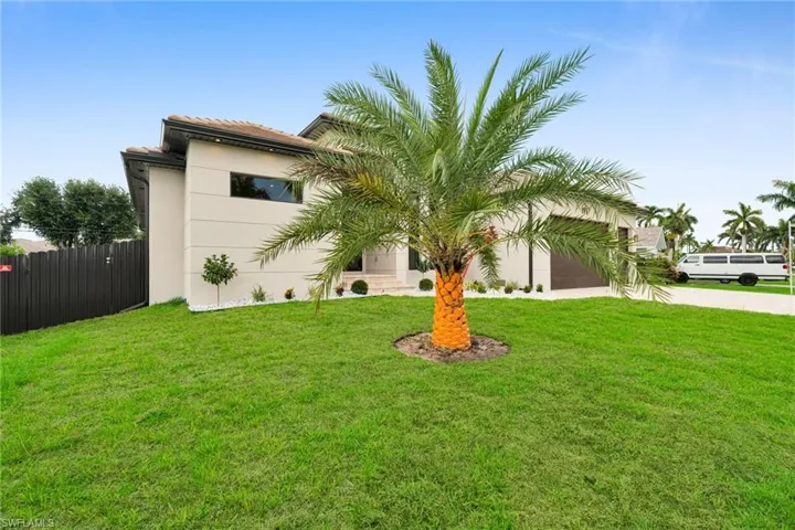 View of front of property with concrete driveway, stucco siding, a tile roof, and a garage