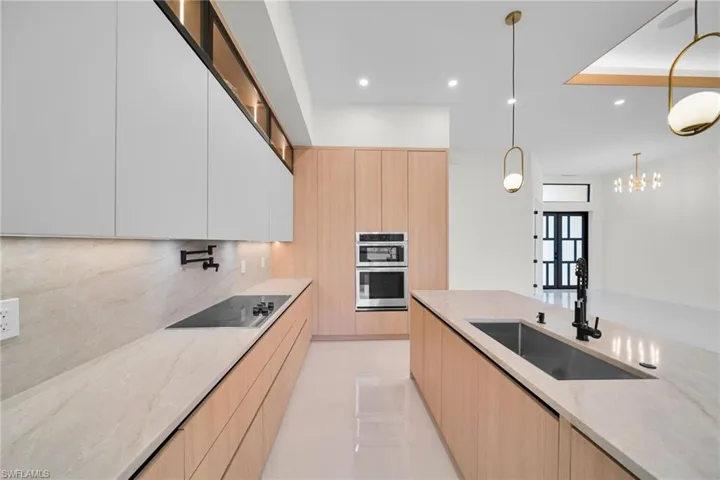 Kitchen featuring modern cabinets, stainless steel double oven, black electric cooktop, decorative backsplash, and recessed lighting