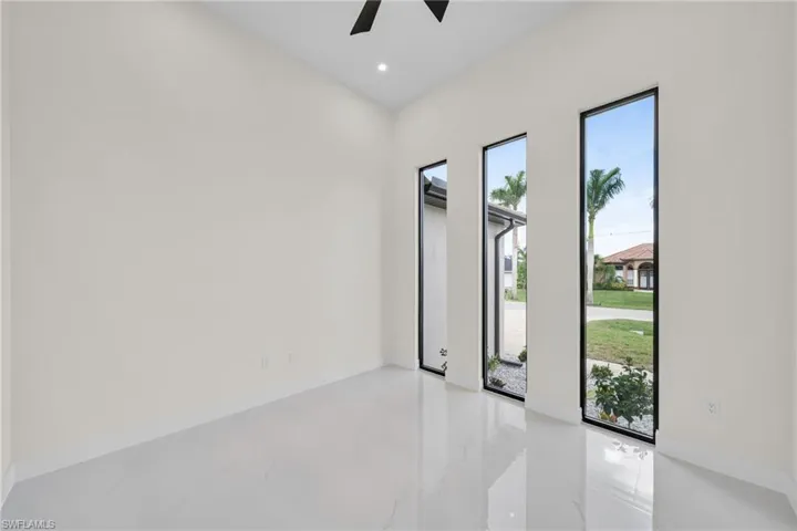 Spare room with healthy amount of natural light, ceiling fan, marble tiled flooring, and recessed lighting