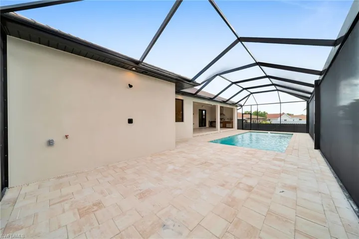 View of swimming pool with a patio and glass enclosure