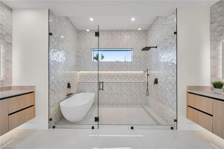 Bathroom with a shower stall, vanity, a freestanding bath, and recessed lighting