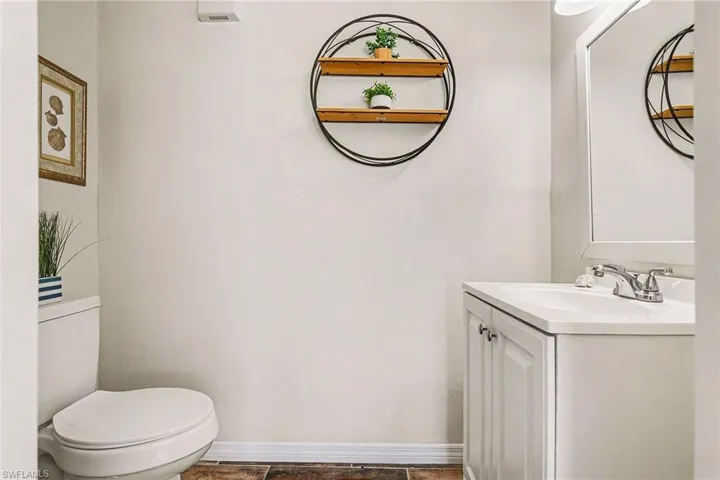 Half bathroom with vanity and stone finish floors