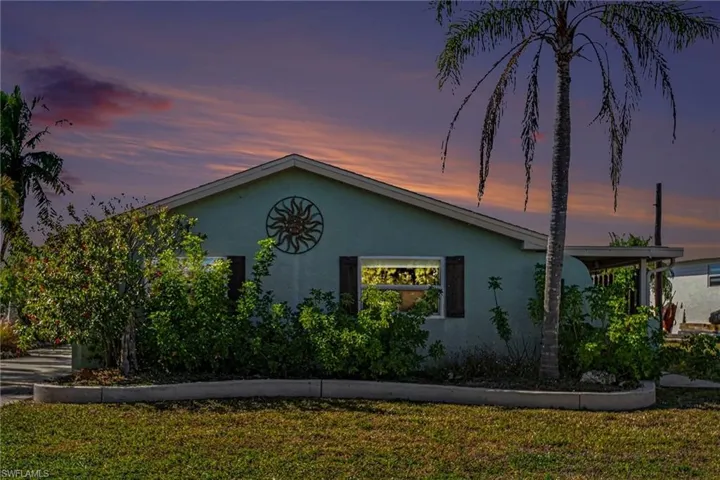 View of front facade featuring a yard and stucco siding