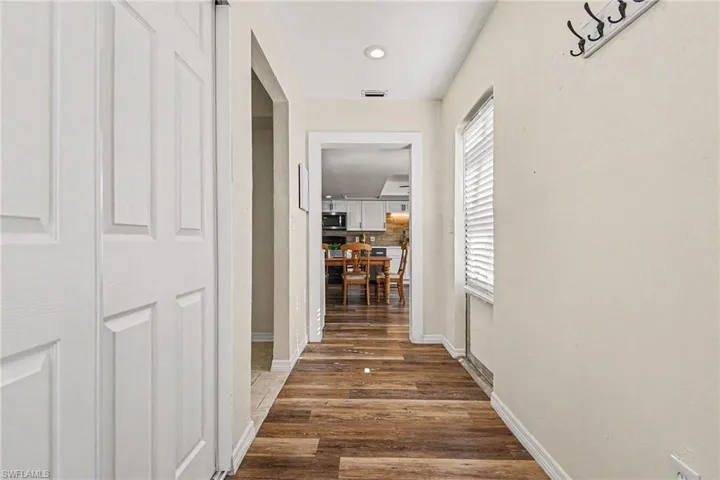 Hall with wood-style floors and recessed lighting