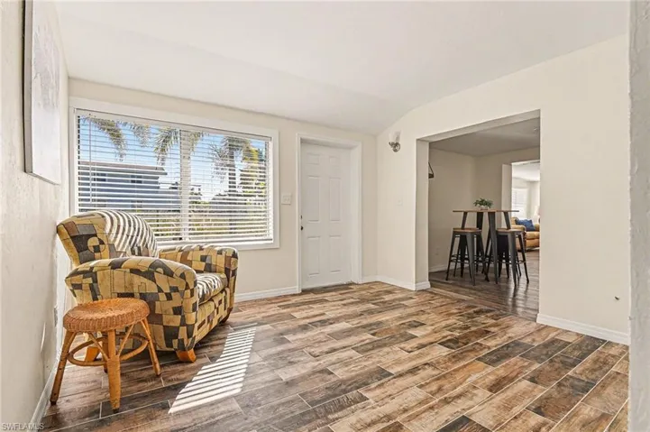Sitting room featuring vaulted ceiling, wood finish floors, and plenty of natural light