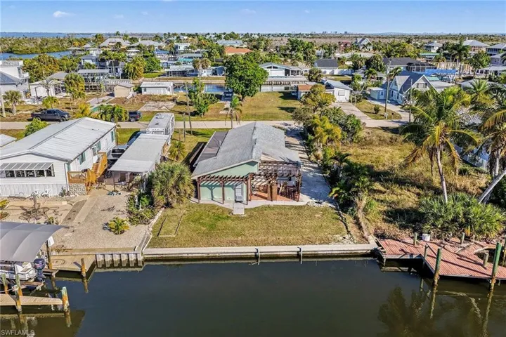 Aerial view of residential area and sea wall featuring a nearby body of water