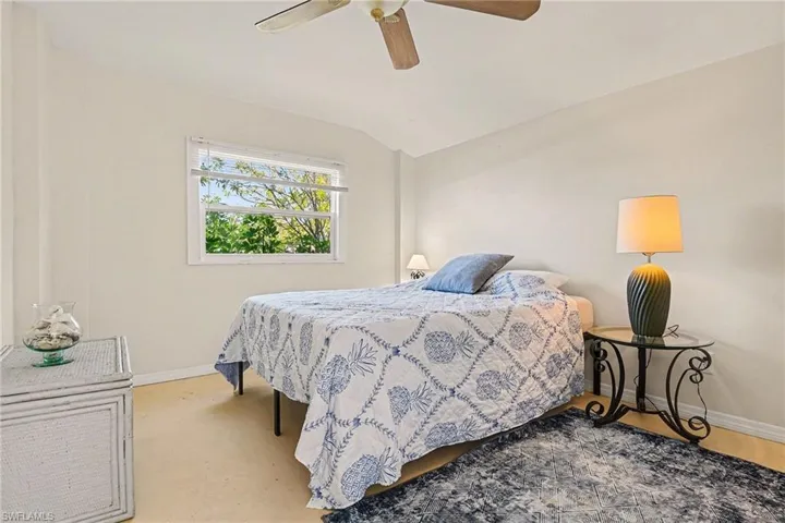 Bedroom with vaulted ceiling and a ceiling fan