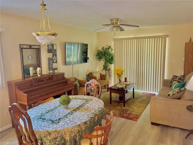 Dining room with a textured ceiling, a ceiling fan, and wood finished floors