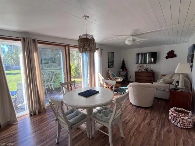 Dining space with dark hardwood / wood-style flooring, wooden ceiling, ceiling fan, and a healthy amount of sunlight