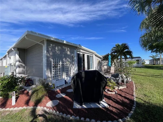View of property exterior with a patio and a lawn