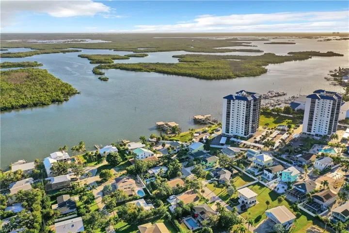 Aerial perspective of coastal residential property featuring waterfront positioning, expansive natural marshlands, and direct access to open waterways