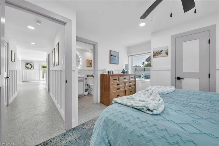 Board-and-batten wall detailing, recessed lighting, multi-panel interior doors with matte black hardware, and an en-suite bathroom featuring a backlit circular mirror