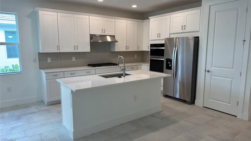 Gorgeous gourmet kitchen with quartz countertops and wood cabinetry
