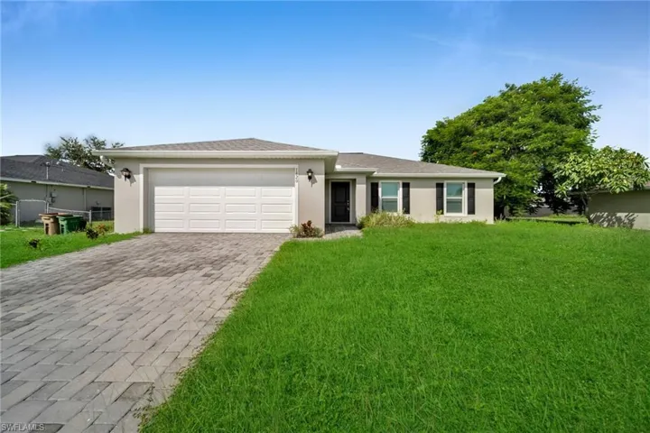Single-story residence featuring a gray exterior, a two-car garage, and a paver driveway