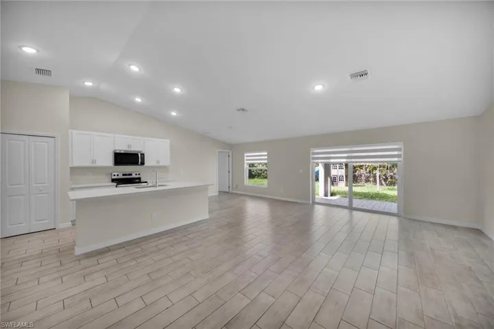 Open-concept living area with vaulted ceilings and recessed lighting