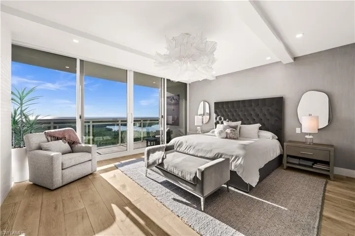 Bedroom featuring access to exterior, beam ceiling, light wood-style floors, and recessed lighting