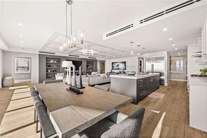 Dining space with light wood-style flooring, hanging lights, and built in features