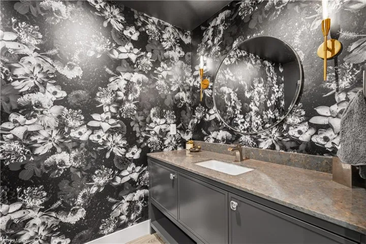 Bathroom with vanity and wallpapered walls