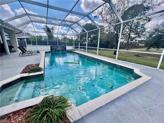 In ground pool with waterfall and a spacious patio