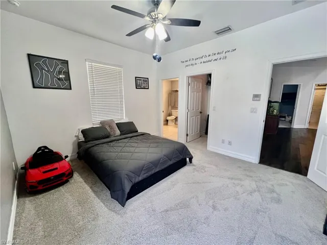 Guest bedroom featuring  ceiling fan, walk in closet and ensuite bathroom