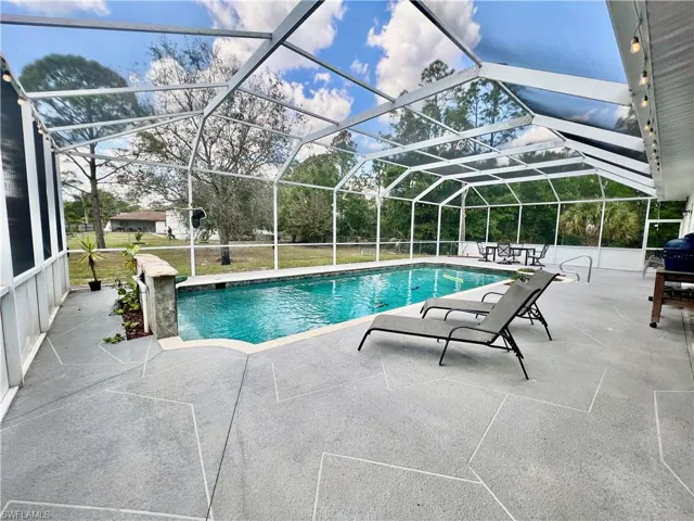 In ground pool with waterfall and a spacious patio