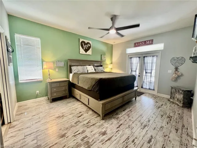 Primary bedroom featuring baseboards, ceiling fan, light wood-style flooring, access to outside, and french doors