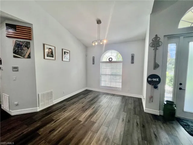 Dining room with soaring high ceilings, and wood-style flooring