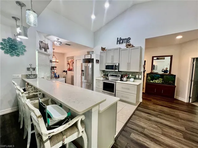 Kitchen with QUARTZ tops, breakfast bar and stainless steel appliances.